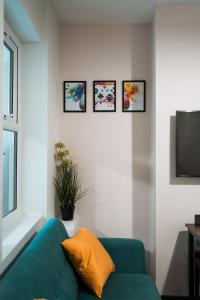 - un salon avec un canapé bleu et quatre photos sur le mur dans l'établissement EDMONTON - 4 bedrooms, Sleeps 8, 3 bathroom Contractor Base, à Londres