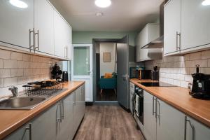 a kitchen with white cabinets and a sink at EDMONTON - 4 bedrooms, Sleeps 8, 3 bathroom Contractor Base in London