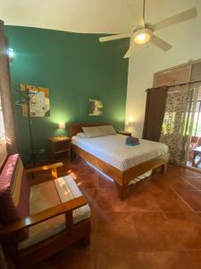 a bedroom with a bed and a green wall at Guesthouse Casa Avi Fauna in Ocotal