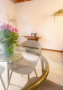un tavolo e sedie con un vaso di fiori sopra di Picnic Apartment a Salionze