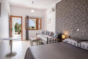 a hotel room with a bed and a table at Perama Hotel, Karpathos in Amoopi