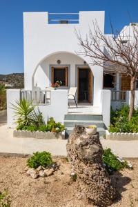 ein weißes Haus mit einem Baum davor in der Unterkunft Perama Hotel, Karpathos in Amoopi