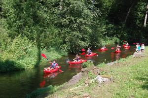 a group of people in kayaks on a river at W sercu Mazur in Kruklanki