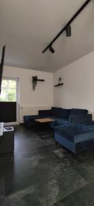 ein Wohnzimmer mit einem blauen Sofa und einem Tisch in der Unterkunft W sercu Mazur in Kruklanki