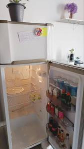 einen Kühlschrank mit offener Tür mit Speisen und Getränken in der Unterkunft Apartamento Loft 03 Ponta Porã MS. in Ponta Porã