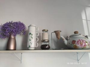 ein Regal mit einer Teekanne und Vasen darauf in der Unterkunft Apartamento Loft 03 Ponta Porã MS. in Ponta Porã