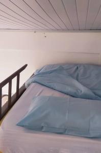a white bed with blue pillows on it at Apartamento Loft 03 Ponta Porã MS. in Ponta Porã