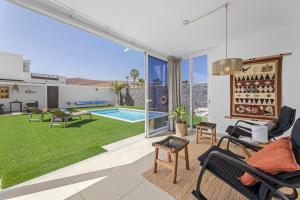 un soggiorno con vista su un cortile e sulla piscina di VILLA GARA a Playa Blanca