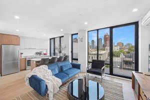 sala de estar con sofá azul y cocina en 149BK-601 NEW PH 2BR-2Bath Private Rooftop W D en Brooklyn