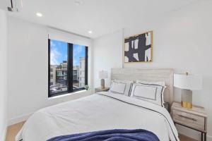 um quarto branco com uma cama grande e uma janela em 149BK-601 NEW PH 2BR-2Bath Private Rooftop W D em Brooklyn
