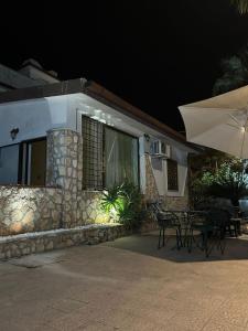 a house with an umbrella and tables and chairs at Villa OLD FISHERMAN'S in Taranto