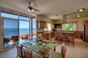 a kitchen with a table and a view of the ocean at 1067 - Villa Diamante in Santa Cruz Huatulco