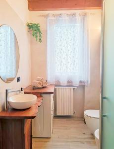 bagno con lavandino, servizi igienici e finestra di Picnic Apartment a Salionze