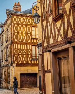 uma mulher a andar numa rua em frente a um edifício em Appartement rez de chaussée avec parking privé em Orléans