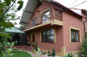 une maison rose avec un balcon. dans l'établissement Ilmar House, à Cluj-Napoca