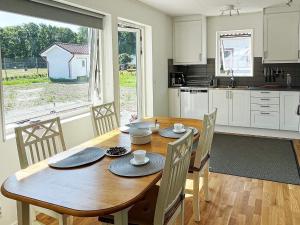 uma cozinha e sala de jantar com uma mesa de madeira e cadeiras em Holiday home SÖLVESBORG X em Sölvesborg