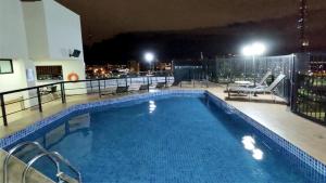 a swimming pool on top of a building at night at Lets Diária Brasil 64138 in Brasilia