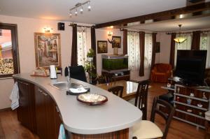eine Küche und ein Wohnzimmer mit einer weißen Arbeitsplatte in der Unterkunft Ilmar House in Cluj-Napoca