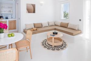 uma sala de estar com um sofá e uma mesa em Piccole Case em Kamari