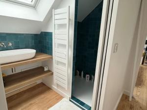 La salle de bains est pourvue d'un lavabo et d'une douche en verre. dans l'établissement Maison familiale au calme, à Lorient