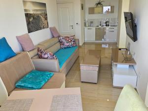 ein Wohnzimmer mit einem Sofa und einem Tisch in der Unterkunft Apartments D'Hermes in Ulcinj