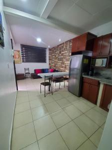 a kitchen and living room with a table and a refrigerator at SUITE AMOBLADA CERCA DEL MALL DEL RIO in Cuenca