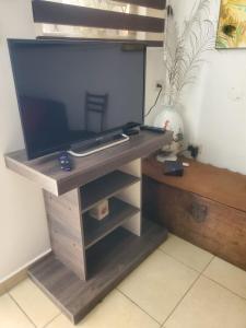 a television on a wooden stand in a room at SUITE AMOBLADA CERCA DEL MALL DEL RIO in Cuenca