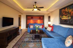 a living room with a blue couch and a tv at Superb 3BR Villa Great view at Cabo San Lucas in Cabo San Lucas