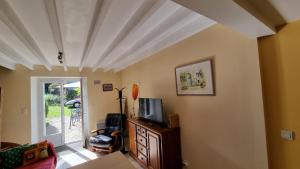 a living room with a tv on a dresser at Gite Les Oyats in Cancale