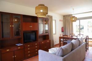 a living room with a couch and a tv at Marina Plaza by Garvetur in Vilamoura