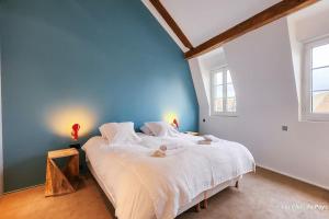 um quarto com uma cama grande e uma parede azul em Superbe maison de standing-plein cœur de Deauville em Deauville