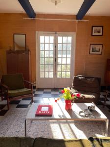 ein Wohnzimmer mit Sofa und Tisch in der Unterkunft Maison Maa , corps de ferme en entier, à 10 min de Saint Valery sur Somme à pieds le long du canal in Boismont + 41 Fotos