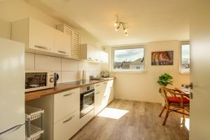 a kitchen with white cabinets and a table with a microwave at Helle Wohnung mit Stellplatz in Hermeskeil