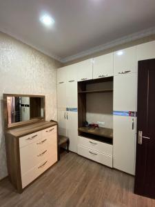 a large kitchen with white cabinets and a counter at Apartment Likani in Borjomi