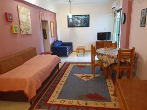 uma sala de estar com uma cama e uma mesa de jantar em ΔΕΛΦΊΝΙΑ em Néa Palátia