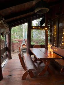 einen Holztisch und eine Bank in einer Hütte mit einem Kamin in der Unterkunft Domek Nowy Lubiel in Lubiel Stary + 31 Fotos