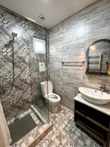 Un baño con ducha, inodoro y lavabo. en Tbilisi Trinity Apartment, en Tiflis