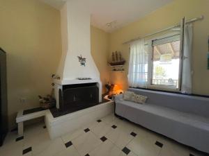 a living room with a couch and a fireplace at POTIDAIA BEACH HOUSE in Nea Potidaea