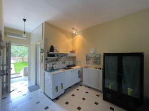 a kitchen with white cabinets and a tv in a room at POTIDAIA BEACH HOUSE in Nea Potidaea