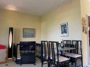a dining room with a table and chairs and a television at POTIDAIA BEACH HOUSE in Nea Potidaea