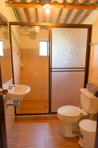 een badkamer met een douche, een toilet en een wastafel bij Cómoda Casa de campo con excelente ubicación in Sogamoso