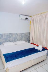 a large bed in a room with a window at Pousada Flat Castor in Natal