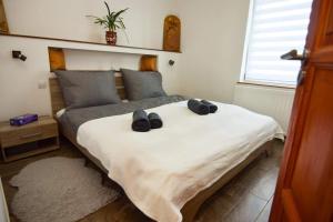 Un dormitorio con una cama con zapatos. en Marco Art Vendégház for 1- 8 persons, 