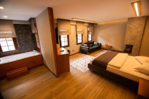 1 dormitorio con 1 cama y bañera en una habitación en Kervansaray Deluxe Hotel en Ayder Yaylasi