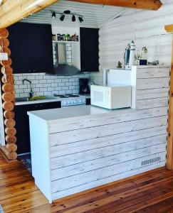 a kitchen with white counters and a white microwave at Bastöstugby stuga 16 in Pålsböle +4 photos