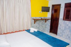 a hotel room with a bed and a television at Pousada Flat Castor in Natal