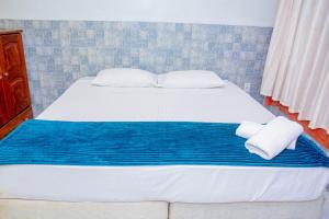 Una cama con dos almohadas blancas encima. en Pousada Flat Castor, en Natal