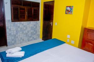 a bedroom with a bed with towels on it at Pousada Flat Castor in Natal