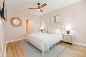 1 dormitorio blanco con 1 cama y ventilador de techo en Sojourn Sanctuary Seaside Escape 3 BR, en Virginia Beach