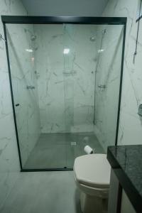 a bathroom with a glass shower with a toilet at Recanto Fogo na Taça (Chalé das Oliveiras) in Jaraguá do Sul